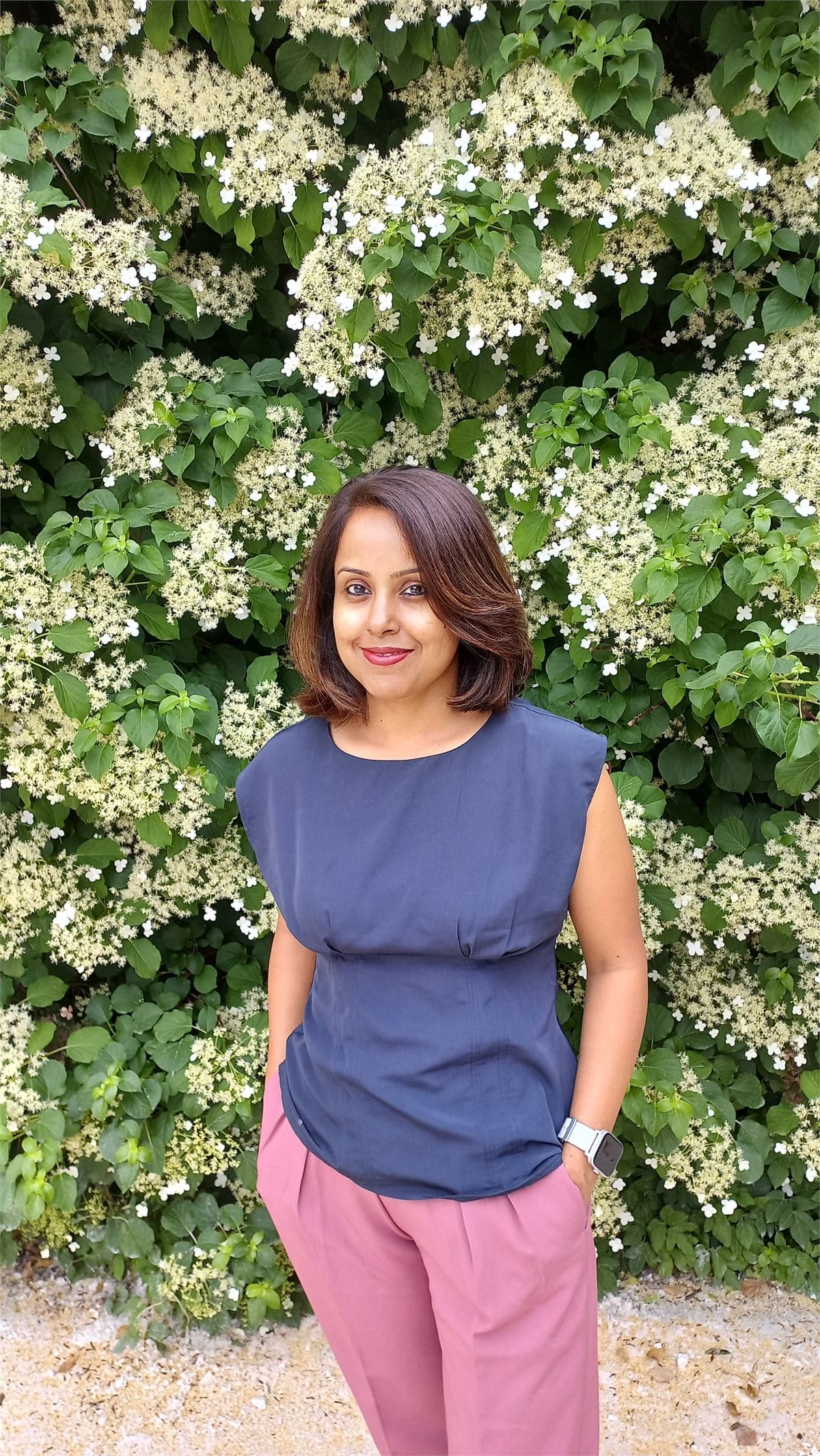 Ruchika in front of flowering greenery